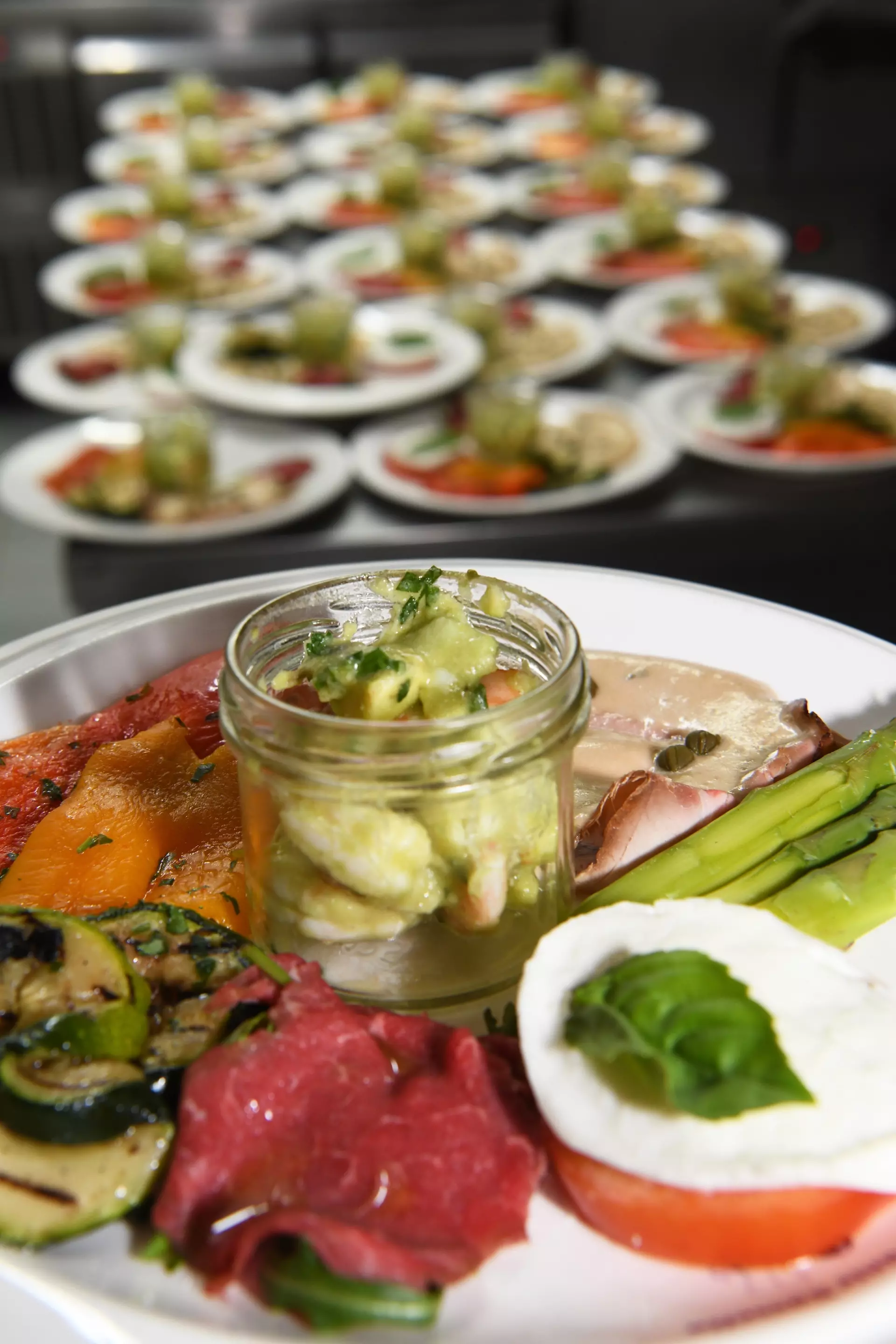 Antipasti-Platte mit Garnelen-Avocado-Salat, Rindercarpaccio, gegrilltem Gemüse und Mozzarella-Tomate.